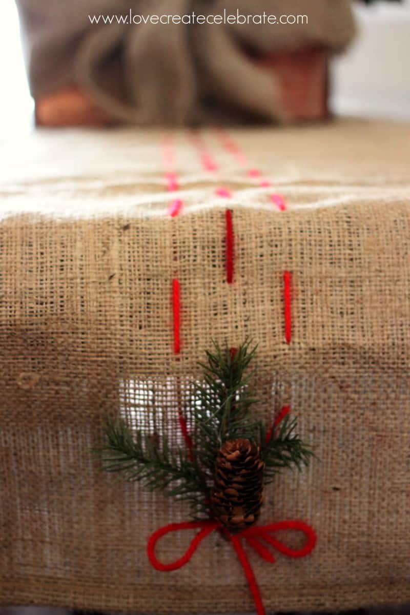 Detail of the burlap table runner, with red thread pulling the burlap Christmas decorations together.