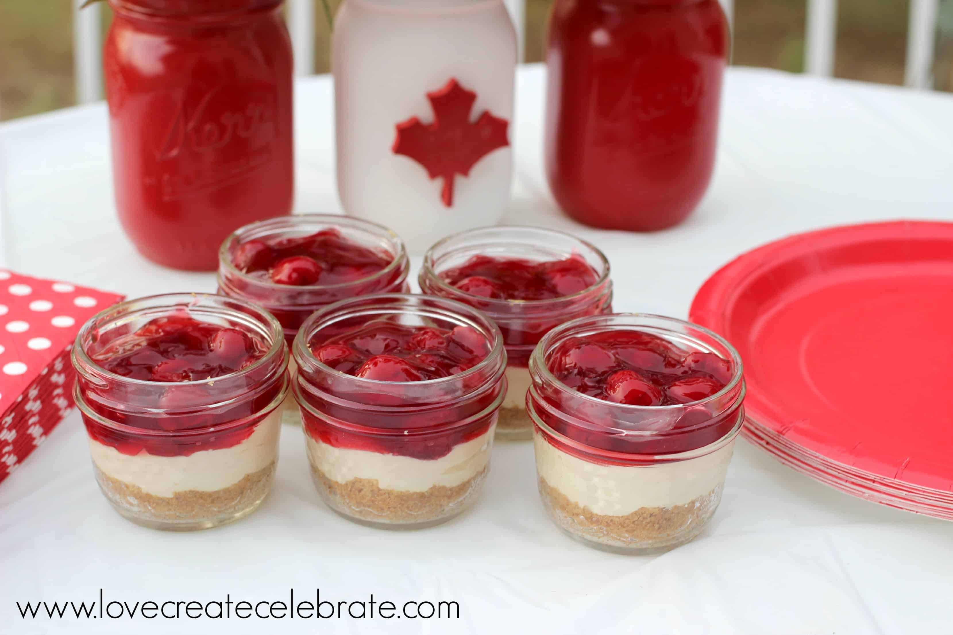 No Bake Cherry Cheesecake individual desserts in mason jars on table