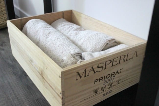 Small wooden crate used to hold towels in the cozy guest room.