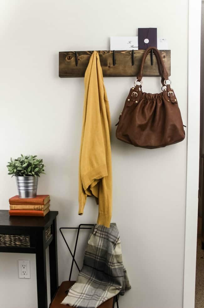 Completed industrial chic coat rack holding a sweater, purse, and mail.