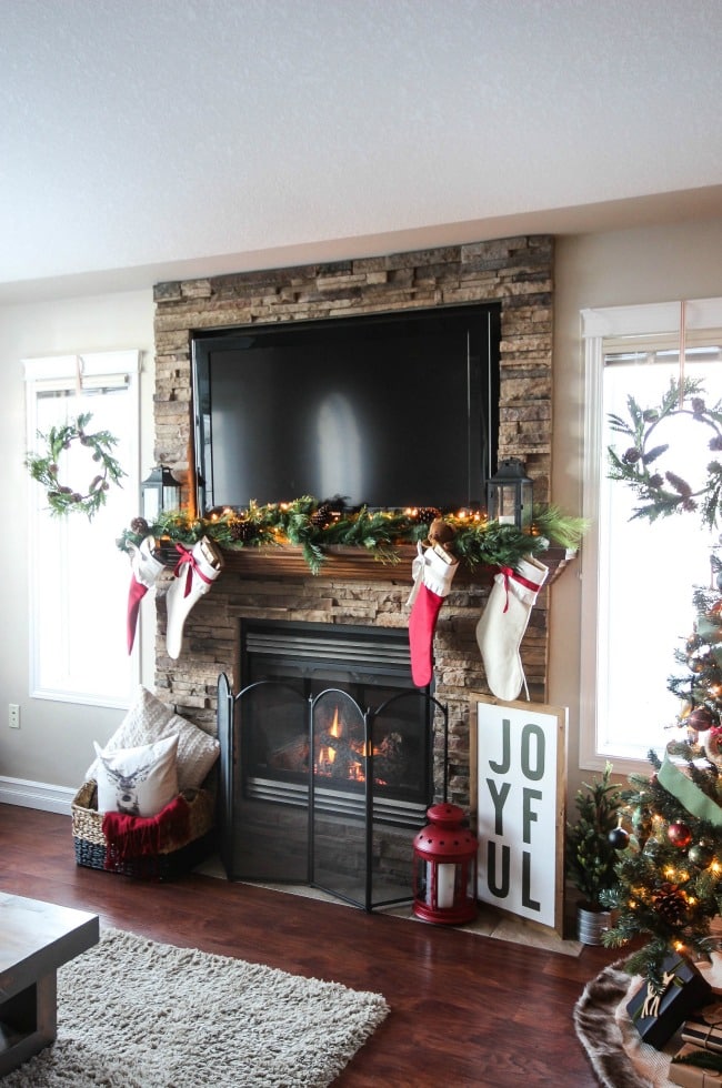 A beautiful rustic fireplace mantel for Christmas! Love the floor to ceiling brick and all of the natural decorations! 