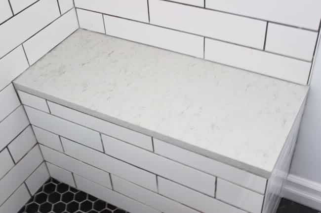 Quartz shower bench with subway tile shower