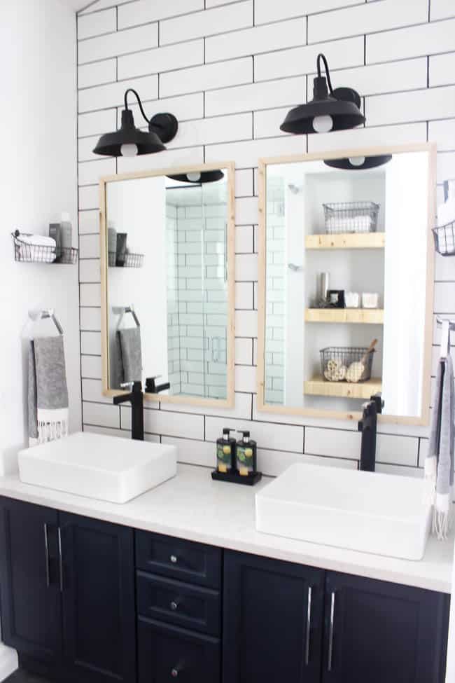 A beautiful modern bathroom renovation with chrome and matte black faucets, sleek modern fixtures and natural wood accents. Beautiful transformation!