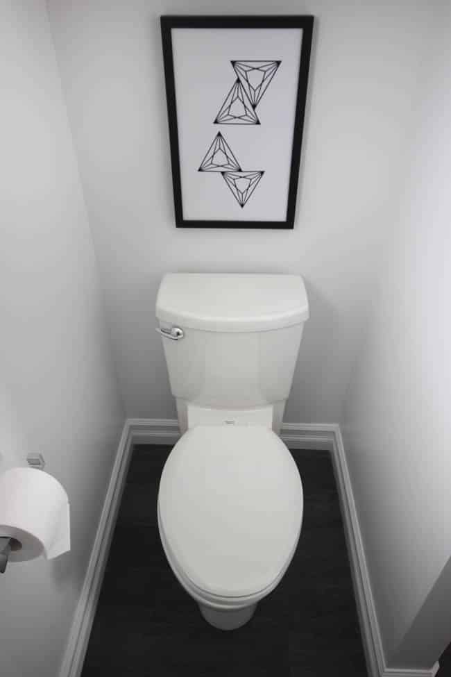 This This modern print looks great above the new, sleek-looking toilet.