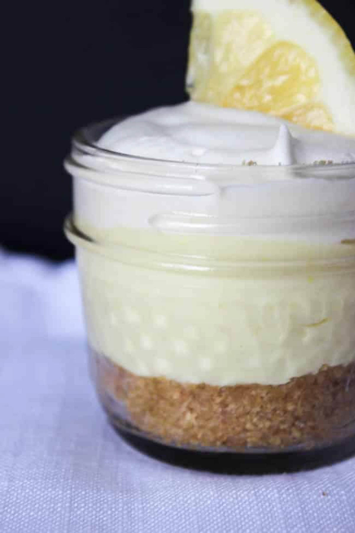 close up of mini mason jar lemon cheesecake dessert