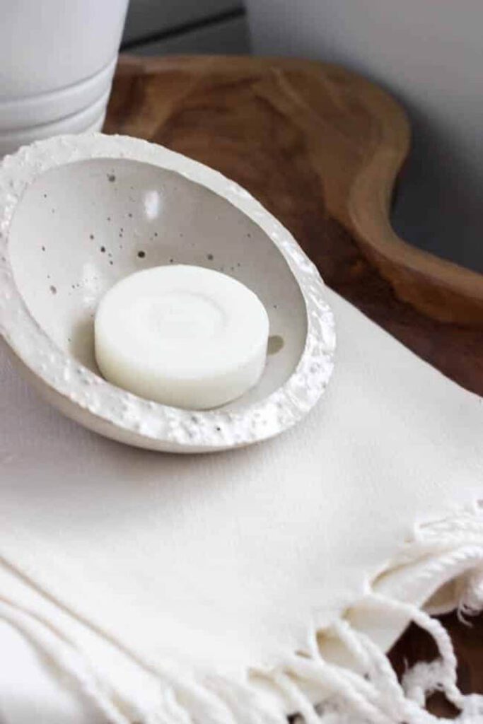 close up DIY soap dish on live edge table next to bathtub
