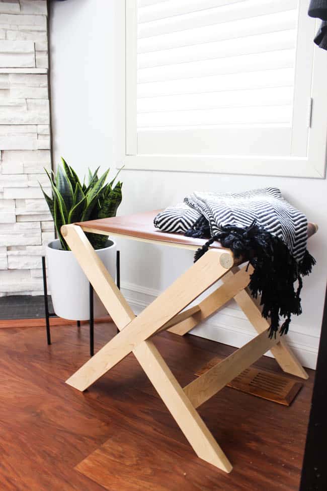 Beautiful design on this modern leather bench. Perfect as a bedroom bench or an entryway bench. The natural wood and brown leather make a beautiful combination! Make your own with these FREE build plans!