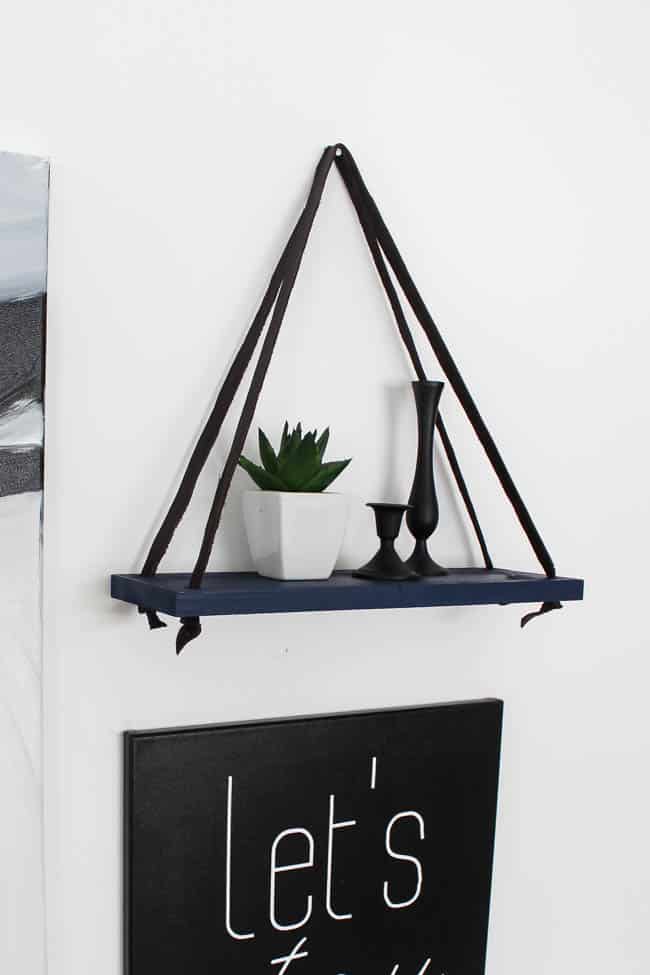 Love this simple modern shelf idea! This simple DIY hanging shelf makes the perfect wall art. If you have some scrap wood and leather you can make this floating shelf in no time! 
