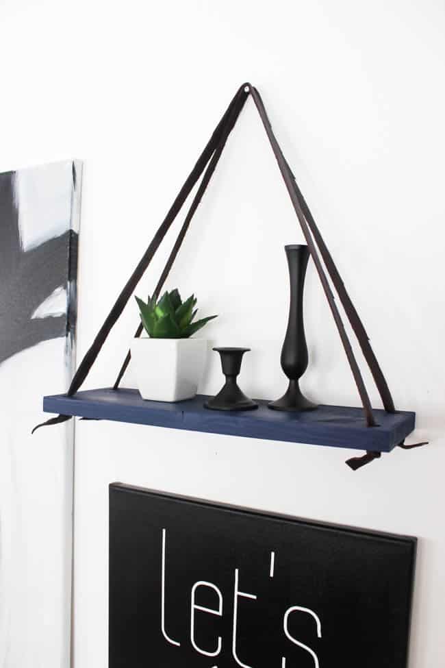 Love this simple modern shelf idea! This simple DIY hanging shelf makes the perfect wall art. If you have some scrap wood and leather you can make this floating shelf in no time!