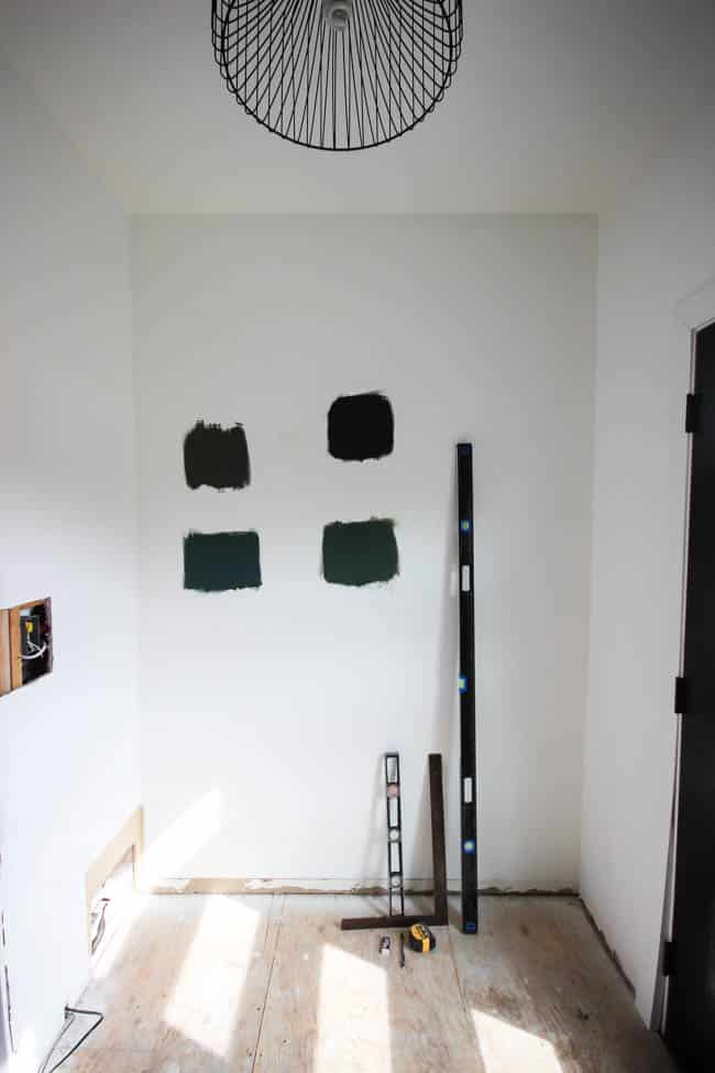 Paint swatches on wall for color choice of the wood accent wall