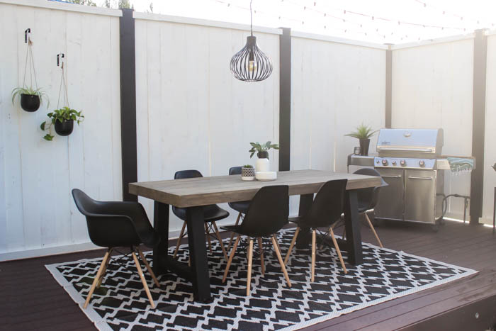 Wow! A beautiful modern outdoor space! The modern table from Article is a stunning addition to this outdoor deck. Finished off with a stunning black and white privacy wall and the gorgeous string lighting! 
