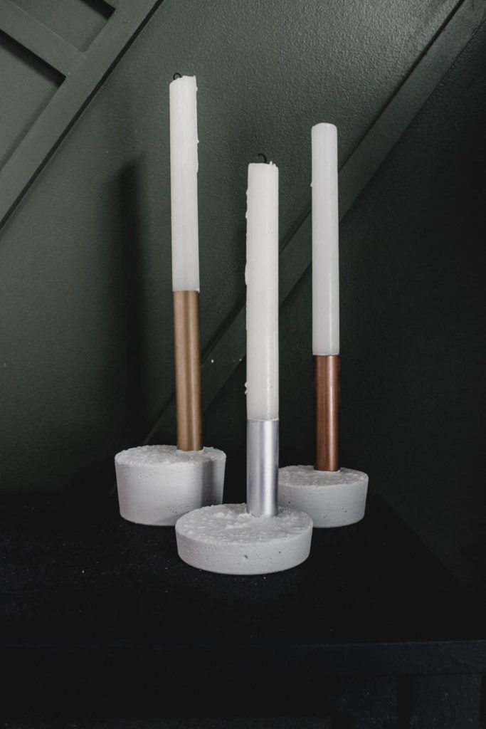 Beautiful metallic candlesticks made with copper pipe, spray paint, and fast drying concrete mix! You'll love this quick and easy DIY project. It's the perfect modern gift idea! #concrete #copperpipe #moderndecor #industrialdecor #industrial #mixedmetals