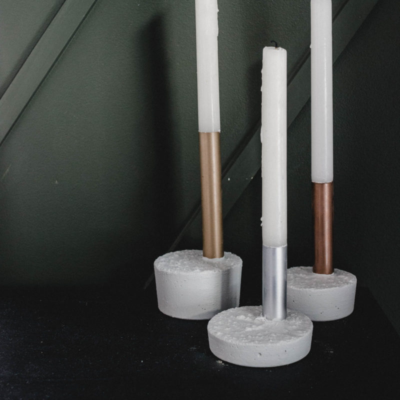 Beautiful metallic candlesticks made with copper pipe, spray paint, and fast drying concrete mix! You'll love this quick and easy DIY project. It's the perfect modern gift idea! #concrete #copperpipe #moderndecor #industrialdecor #industrial #mixedmetals