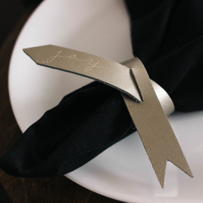 Beautiful modern leather napkin rings! Love the subtle messages on these gorgeous napkin holders! Make your own and learn to cut leather with the Cricut Explore Air 2 or Cricut Maker. Love this idea for my next table setting! #cricutmade #leather #ironon #craft #modernDIY