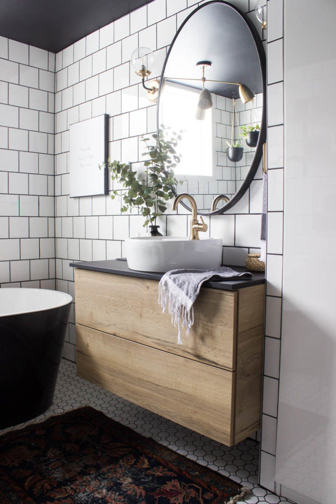 Wow! This modern Bathroom Reveal is absolutely stunning! What a gorgeous space! Everything from the black tub and shower frame, the champagne bronze faucets, and the wood vanity to the black ceiling and built-in storage units! What an incredible transformation! #modernbathroom #paintedceiling #blackceiling #blackandwhite #bathroom #remodel #renovations