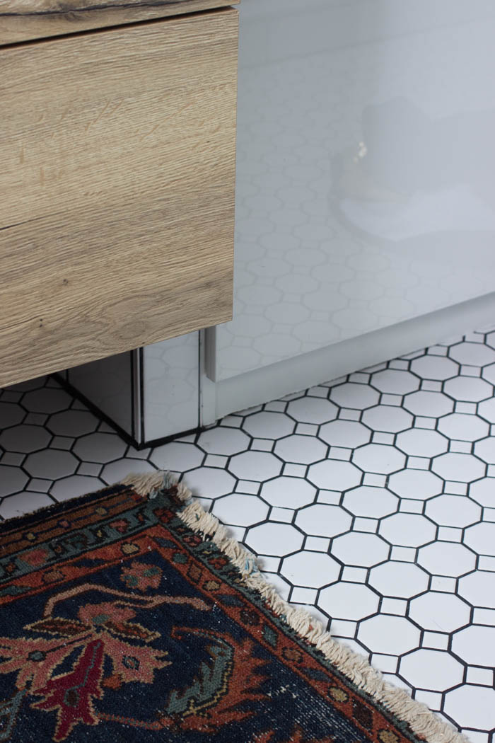Tile flooring and rug in the modern bathroom reveal.