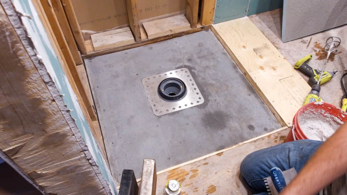 How to install a shower pan and drain. A great video tutorial and step-by-step guide to installing a shower pan or base and drain. Also shares how to install the waterproofing system using the Ubau Flo kit. #renovations #renobloggers
