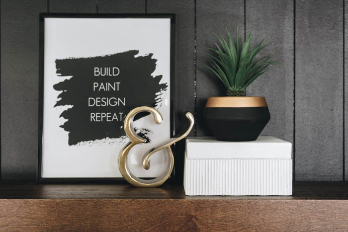 image of framed quote, ampersand, and small plant sitting on the fluted box