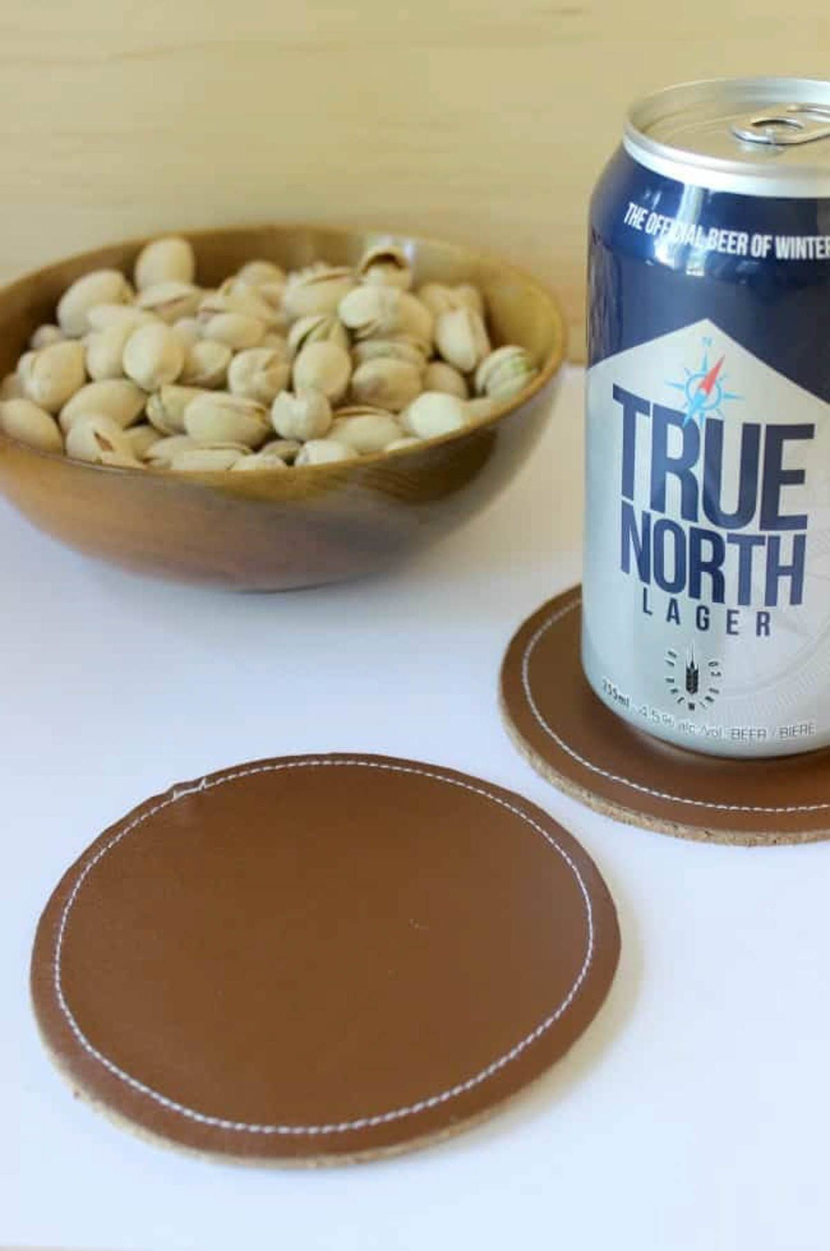 Leather coasters displayed with a can and nuts