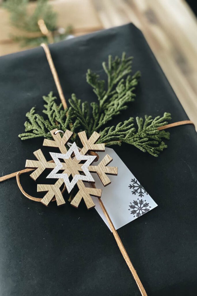 wooden snowflake and greenery on gift