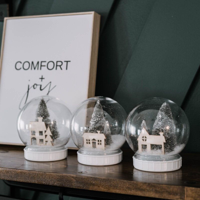 DIY snow globes made from Dollar store supplies sitting on a shelf
