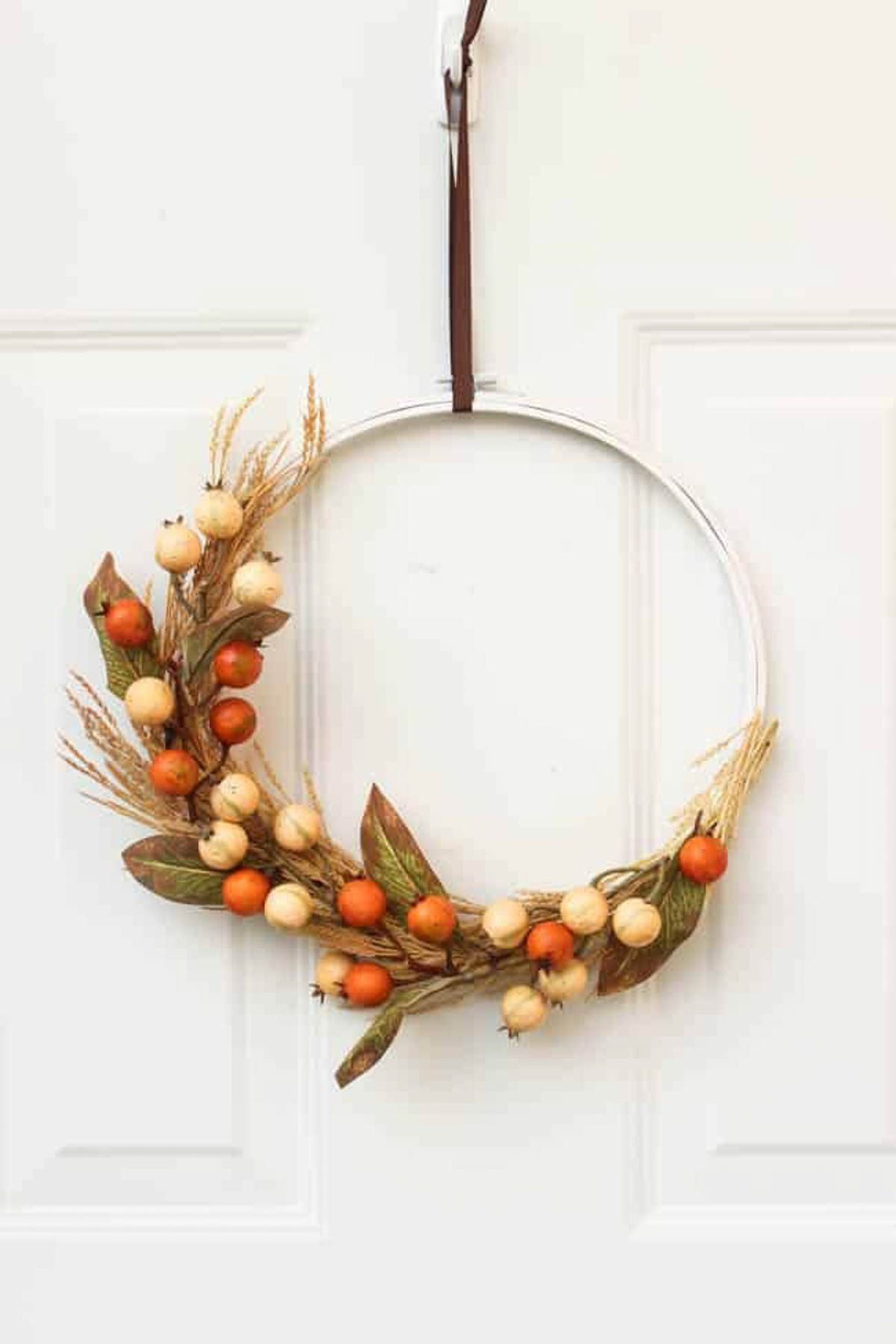 Autumn embroidery hoop wreath hanging on a door.
