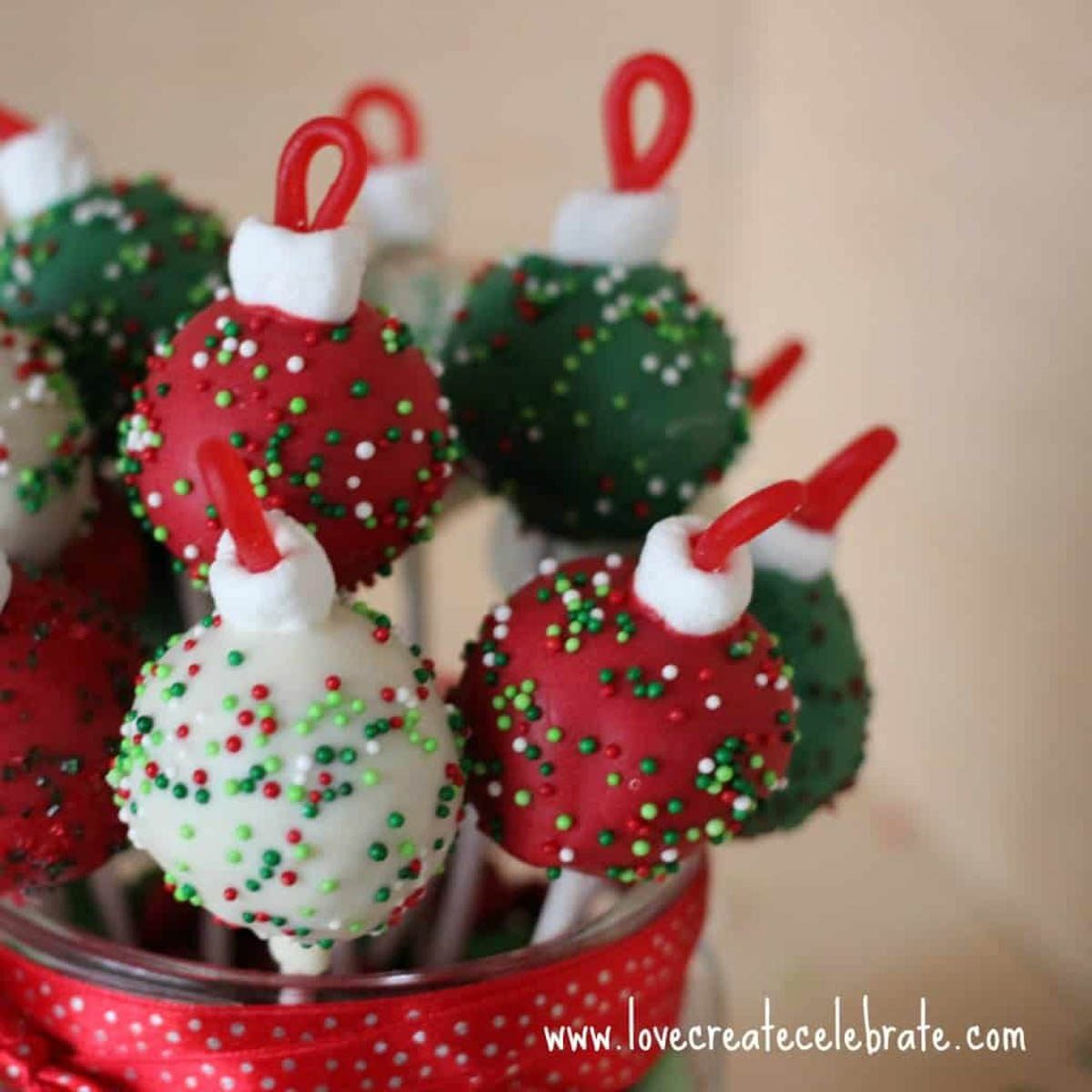 Close up image of red, green, and white ornament cake pops.
