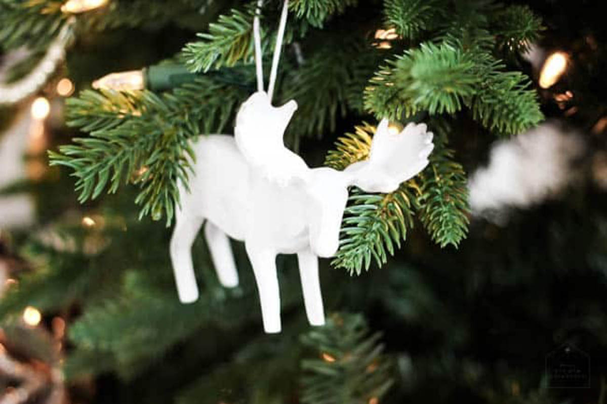 White moose ornament on a decorated designer Christmas tree.