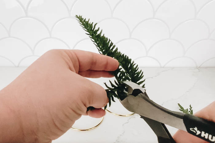 cutting faux greenery pieces for the Christmas wreath ornament