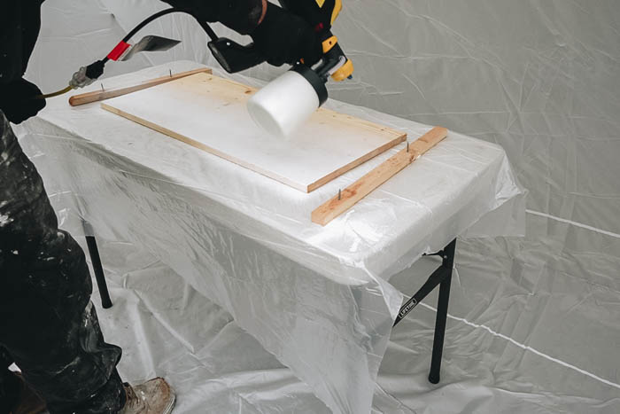 applying stain with sprayer 