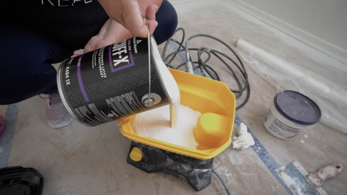pouring paint into paint sprayer